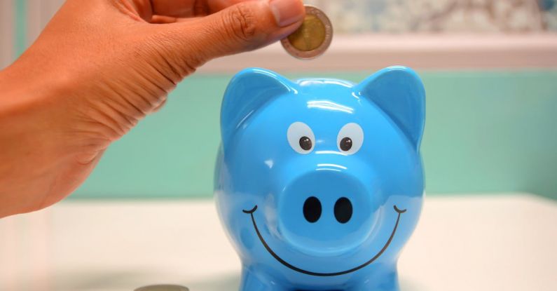 Saving - Person Putting Coin in a Piggy Bank