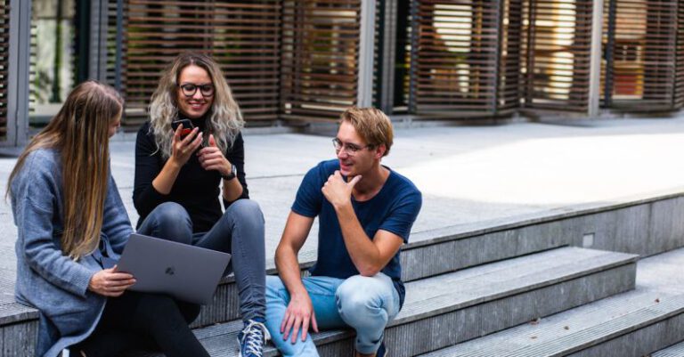 Student Loan - Three Persons Sitting on the Stairs Talking With Each Other