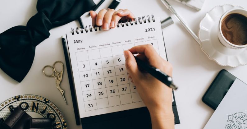 Days - A Person Writing on a Desk Calendar